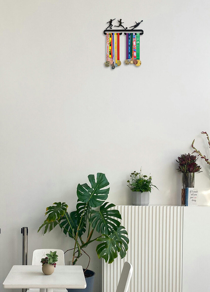 Poikien jalkapallo-aiheinen teräksinen mitalihenkari huoneen sisustuksena.