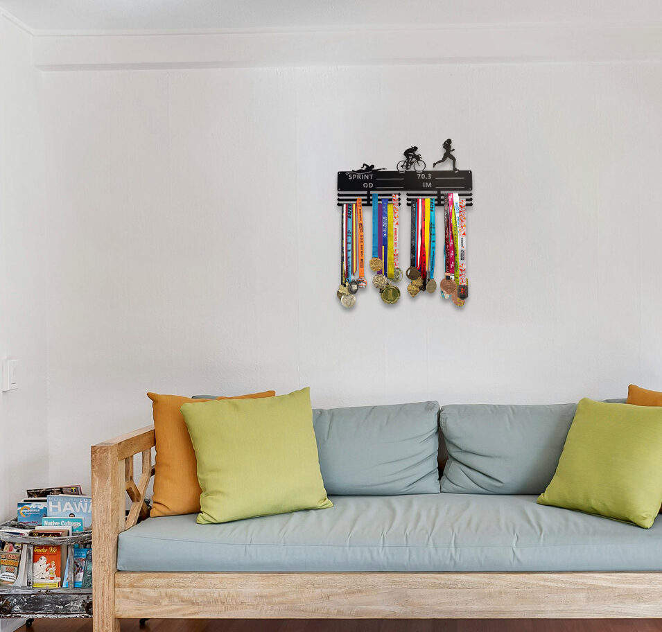 Triathlon-aiheinen jättikokoinen mitalihenkari, missä naishahmo ui, pyöräilee ja juoksee.